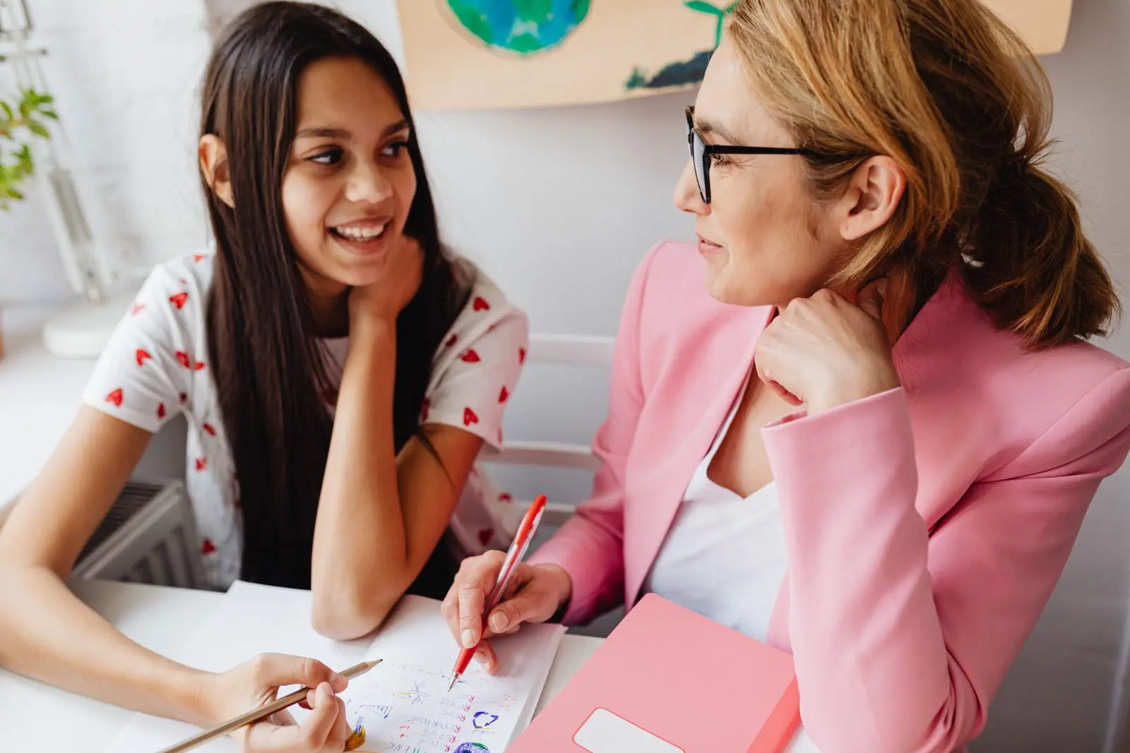 A mentor and a young person working together on a project